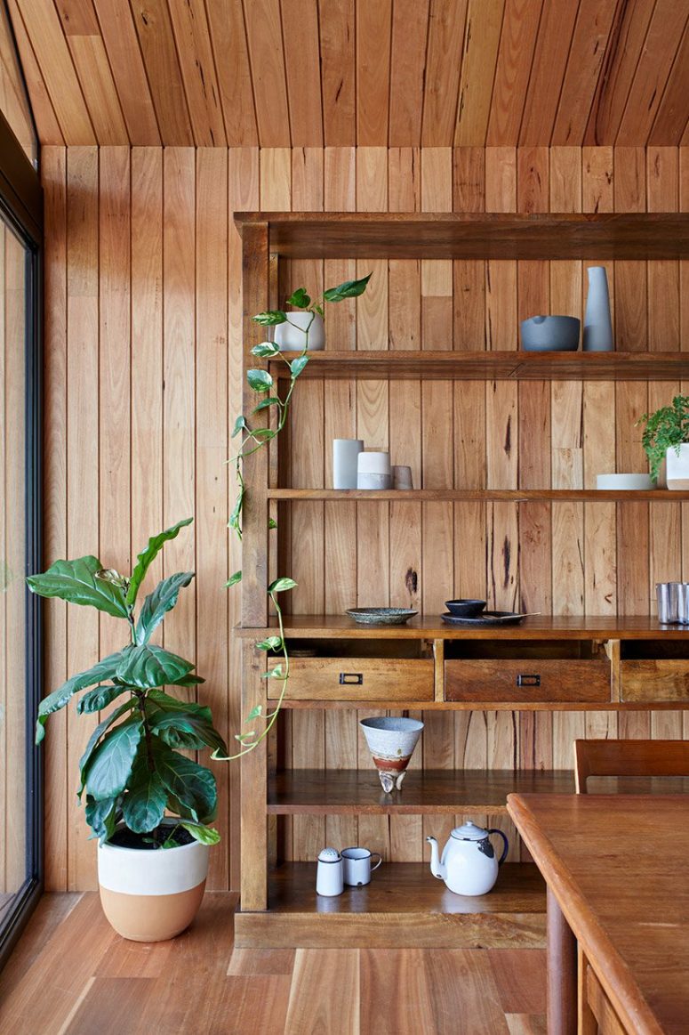 The dining space is done with a large open shelving unit for storage and displaying