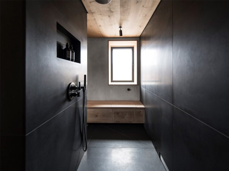glam moody bathroom design The master bathroom is done with black tiles and concrete and wood to tie it up with other spaces