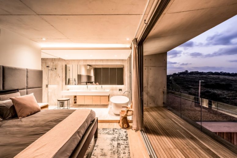 a gorgeous bedroom combined with a bathroom The master bedroom is united with the bathroom, there's a large bed, a bathtub in the bedroom, a large vanity and lights plus a large balcony