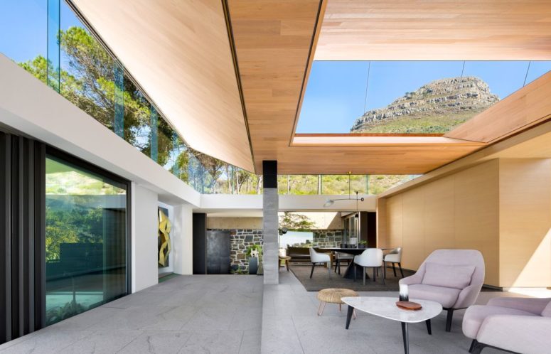 The living space is done with chairs and a table, skylights and extensive glazing fills the house with light The living space is done with chairs and a table, skylights and extensive glazing fills the house with light