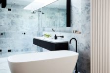 08 a minimalist bathroom with a comfy free-standing bathtub and marble tiles for a chic look