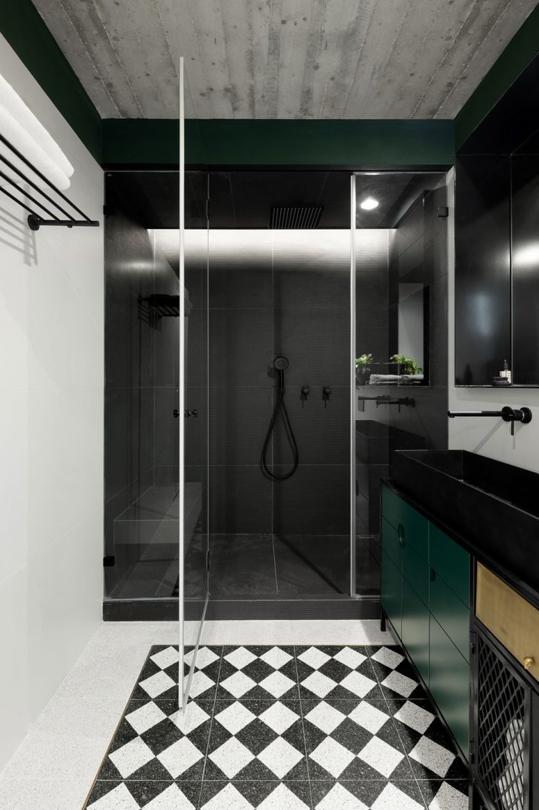 The bathroom is done in black, white and emerald, with geometric patterns to tie the spaces