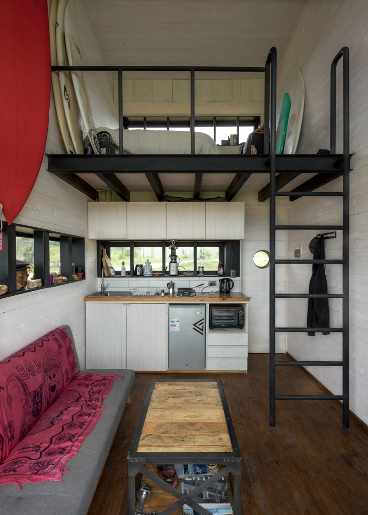 This is a tiny self-sufficient home with a bedroom, a living room and a kitchen