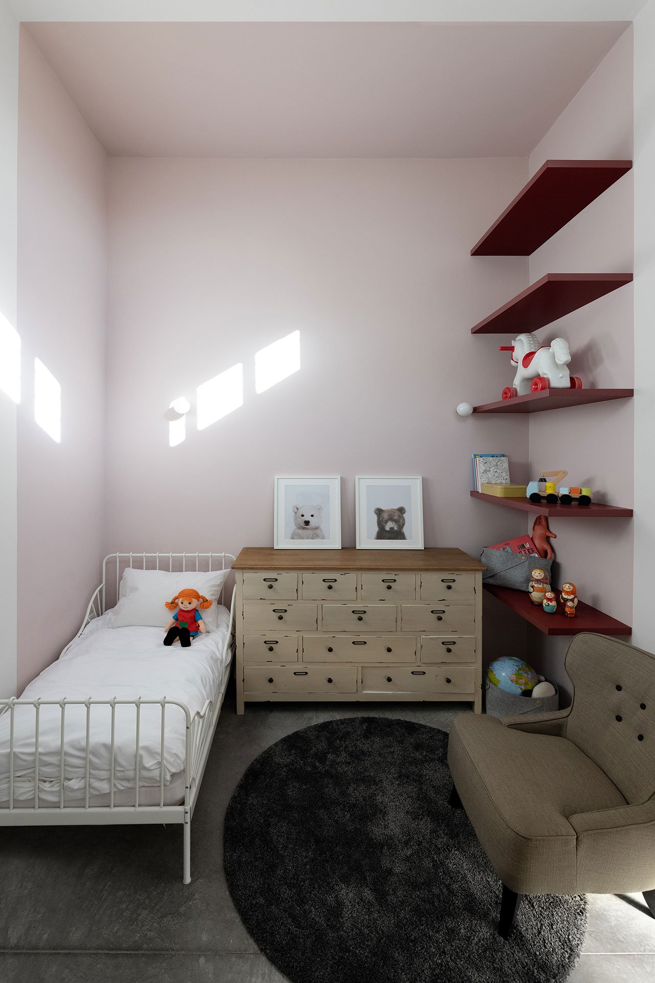The kid's room is done with light pink, neutrals and open shelving