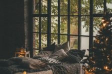 cozy bedroom decorated for christmas with a tree and lights