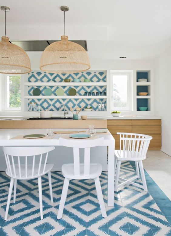 blue and white mosaic tiles clad the backsplash and the floor bring strong Mediterranean vibes to the kitchen