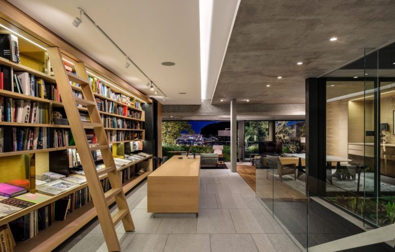 A large and sophisticated home office occupies a section of the middle floor and features an entire wall of bookshelves