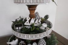 12 a Christmas etagere with evergreens, pincones, jingle bells, candle holders and letters