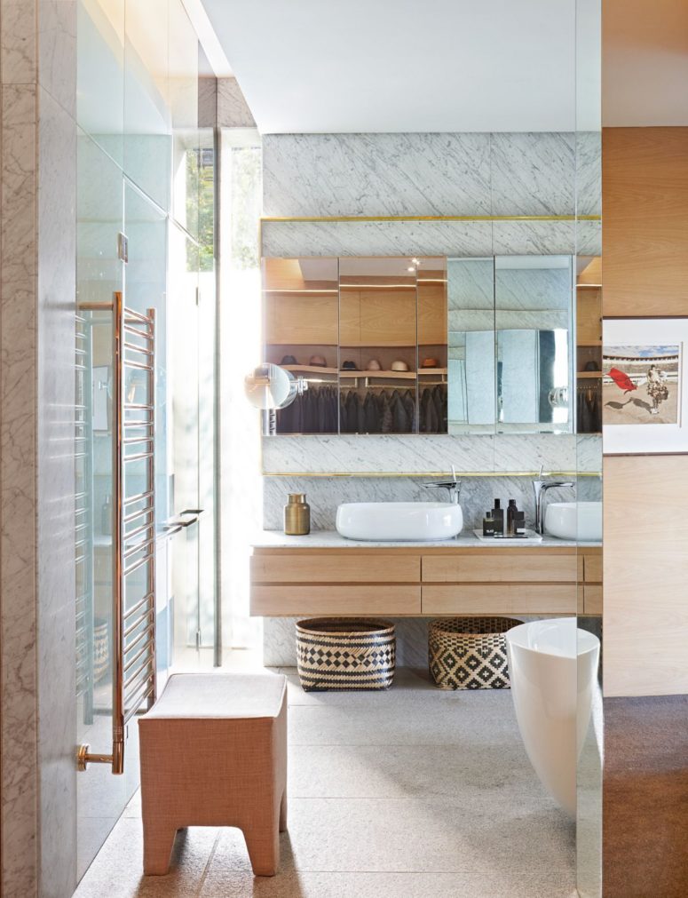 The bathrooms are as stylish as the rest of the house, featuring white marble walls and glass enclosures