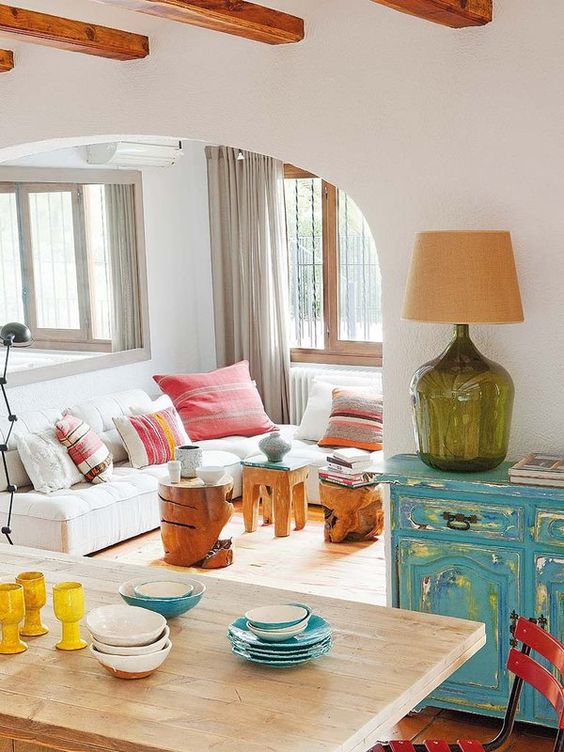 a bright turquoise shabby chic sideboard, some wood carved stools and colorful textiles make up the space a bright turquoise shabby chic sideboard, some wood carved stools and colorful textiles make up the space