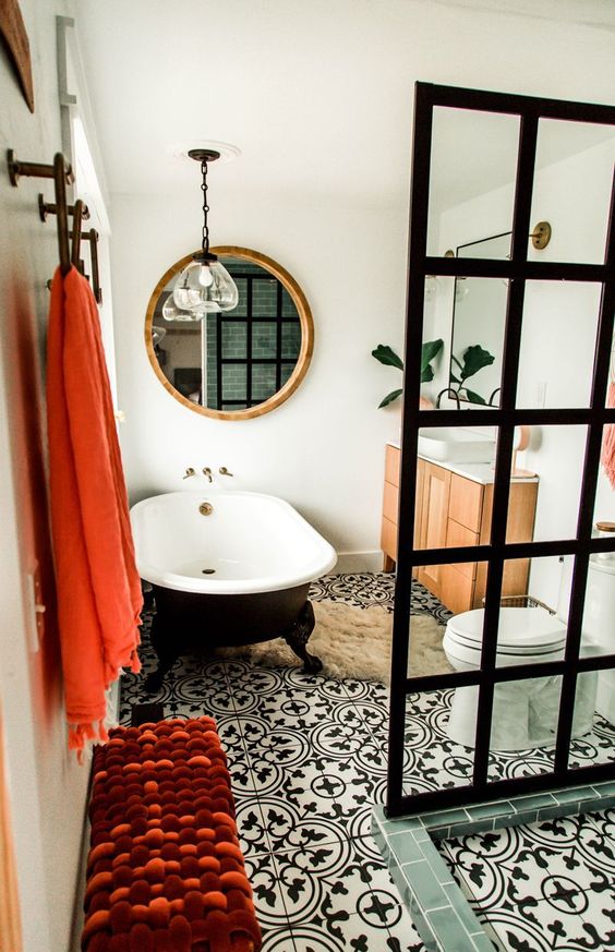 a mid-century modern meets contemporary bathroom done in black and white and accented with coral
