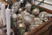 15 a crate filled with vintage silver ornaments and evergreens is great for any space if your tree can’t accommodate them