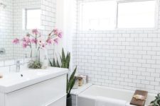 16 a bathroom clad with subway tiles accented with black grout and black hexagon tiles on the floor is trendy