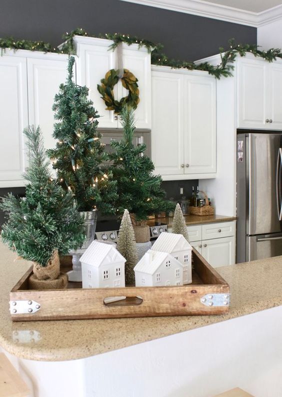 a tray with houses, tinsel Christmas trees in burlap with lights is a cool rustic decoration