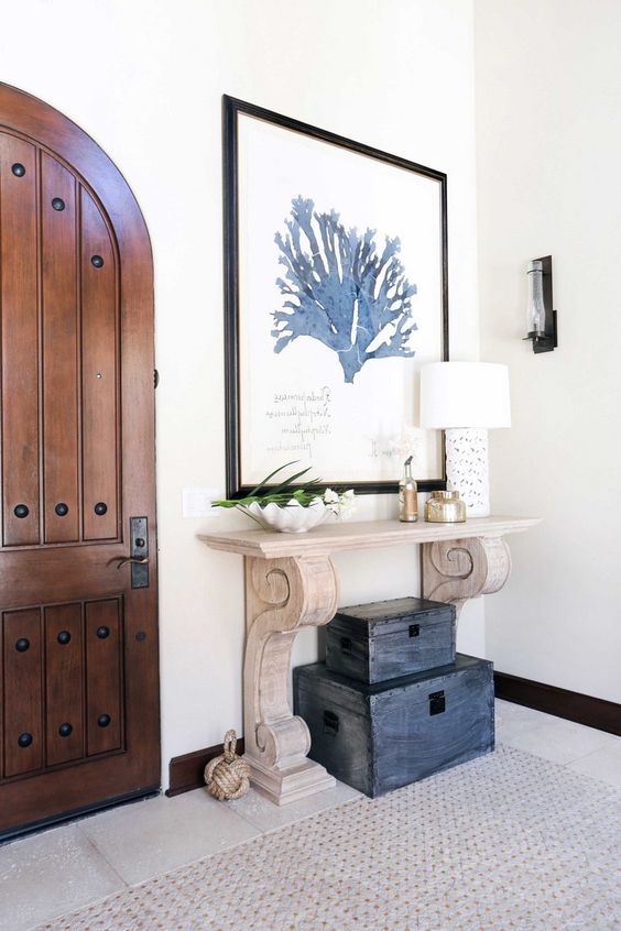 a wood carved console and a stack of vintage chests make the entryway really beachy and Mediterranean a wood carved console and a stack of vintage chests make the entryway really beachy and Mediterranean