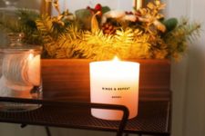 18 place a winter scented candle and a box with evergreens, pinecones and fake berries to achieve a holiday look