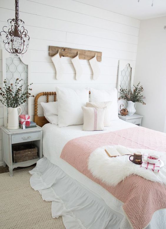 a cozy vintage farmhouse bedroom with faux fur, white stockings, dried herb arrangements and a striped blanket