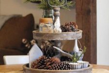 20 a two-tiered tray with pineccones, evergreens, candles and antlers for a woodland or natural feel
