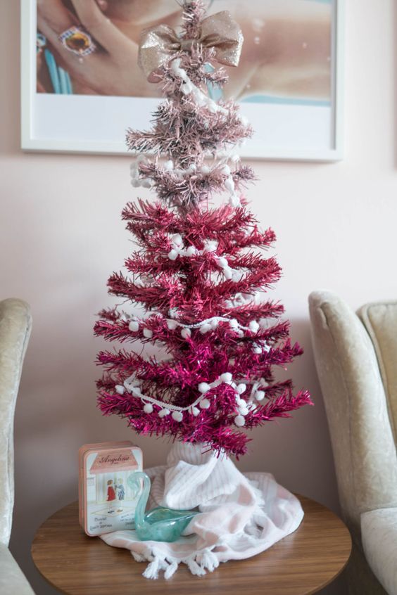 a little ombre blush to hot pink Christmas tree decorated wit pompoms and a glitter bow can be DIYed very fast and easily