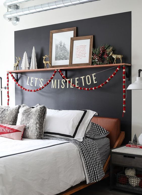 a modern Christmas bedroom with a chalkboard wall, a pompom garland, faux fur and a shelf with gilded deer