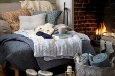 22 a super cozy nook with a large lounger with fabric and knit pillows, knit blankets and fabric throws