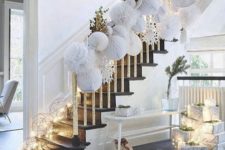 22 a white hallway with a faux fur rug, white paper ornaments attached to the railing and lots of light lining up the stairs