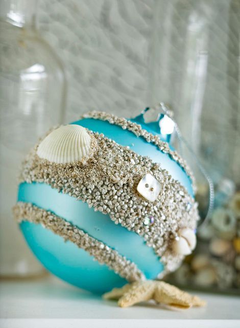 a turquoise Christmas ornament with beach sand, buttons and seashells can be DIYed
