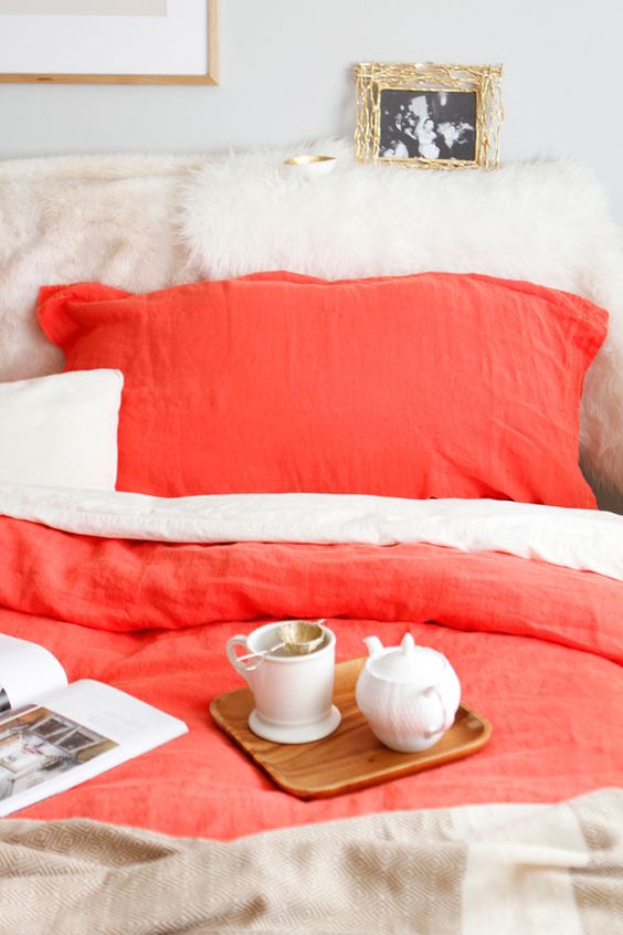 neutral bedding with coral accents is a gorgeous way to incorporate this trendy color into your bedroom decor