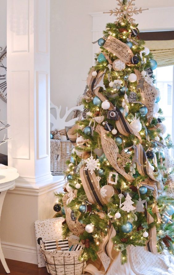 a chic Christmas tree with a vintage flavor, blue, white and black ornaments and striped and music note ribbons