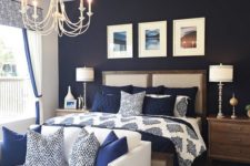 03 a bedroom with a navy statement wall, navy and white bedding and a creamy couch with navy pillows