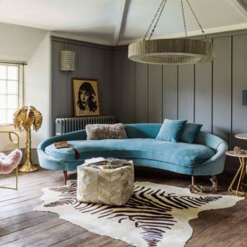a refined and chic blue curved couch brings color and a sophisticated feel to the living room
