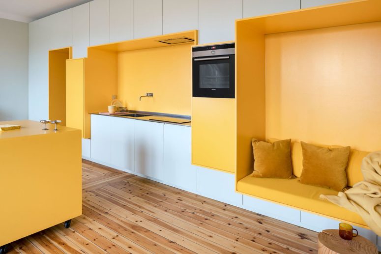 A yellow seat features an integrated kitchen unit and a comfy seat with pillows