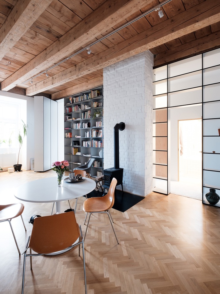 The dining space shows off a round table, leather chairs and a wood stove for a refined feel