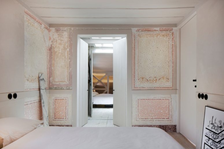 The bedroom is done in all neutrals, there's a large bed and some original frescoes that make a statement