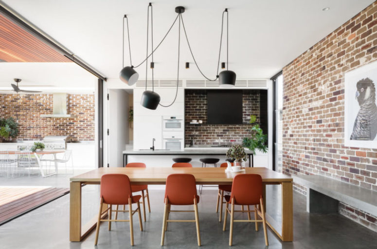 The indoor kitchen is done with white cabinets, a black hood and a comfy kitchen island