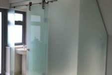 05 a bathroom cubicle clad with frosted glass and with a main sliding door is a bold idea for a modern space