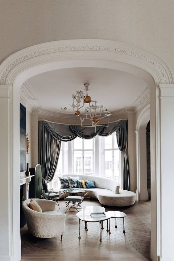 an exquisite neutral curved couch and a curved chair soften the room making it more inviting