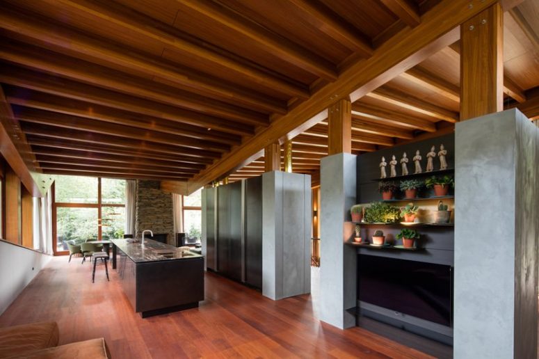 The kitchen is contemporary, with glass and concrete cabinets, a large kitchen island and even an inner garden