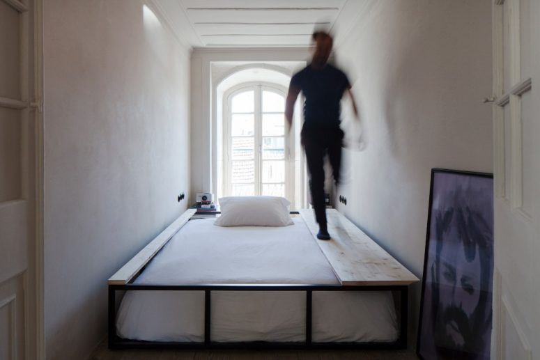 The second bedroom shows off a bed that can be easily covered and turned into a sitting space