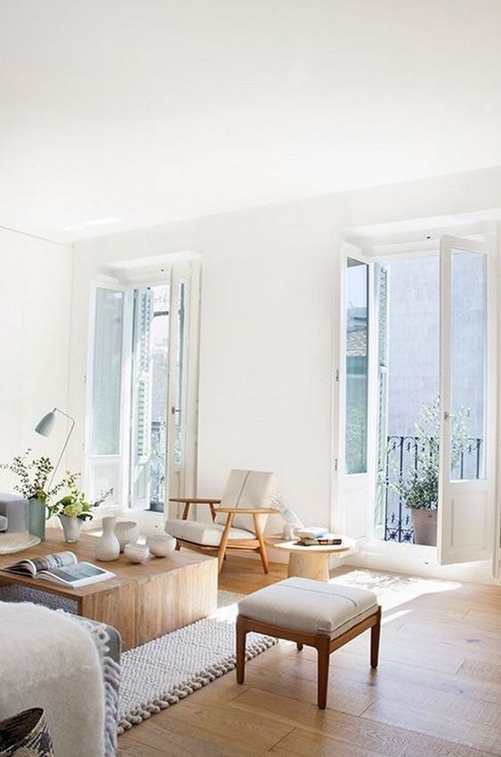 a neutral living room with wooden furniture and a comfy rug looks very fresh