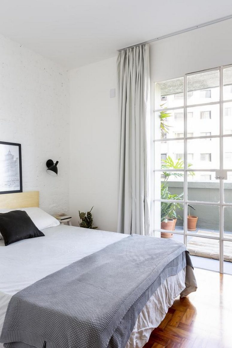 The bedroom is all neutral, whitewashed brick walls create a cool base, and textiles add a texture