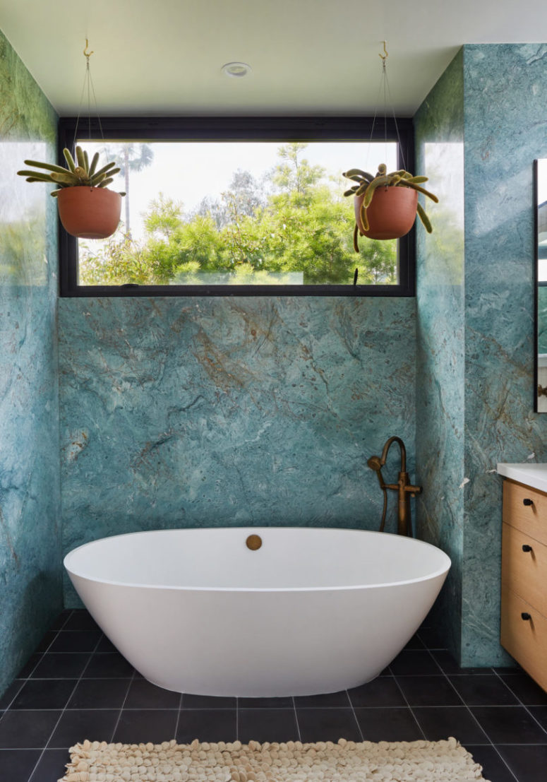 The bathroom is done with black tiles on the floor and blue Carrara stone that really impresses