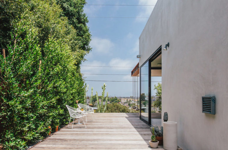 There's a large outdoor deck with some potted cacti and plants