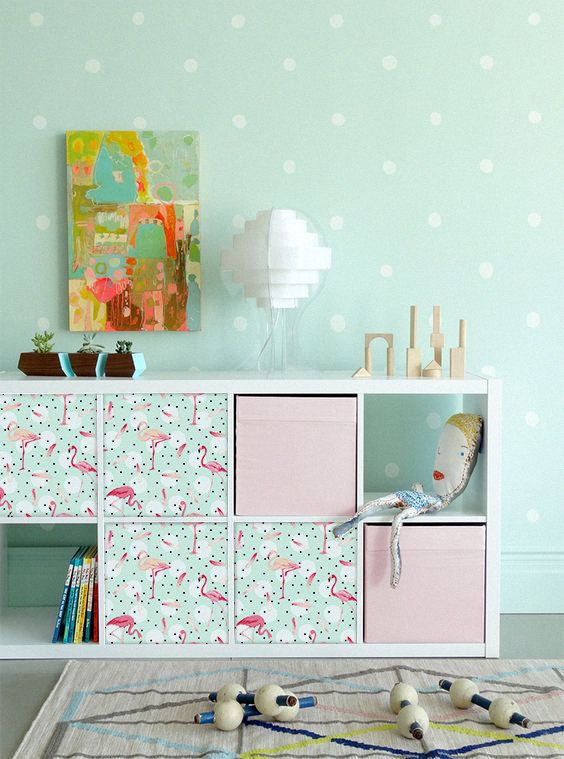 a Kallax shelving unit with Drona boxes and flamingo bird stickers attached to them