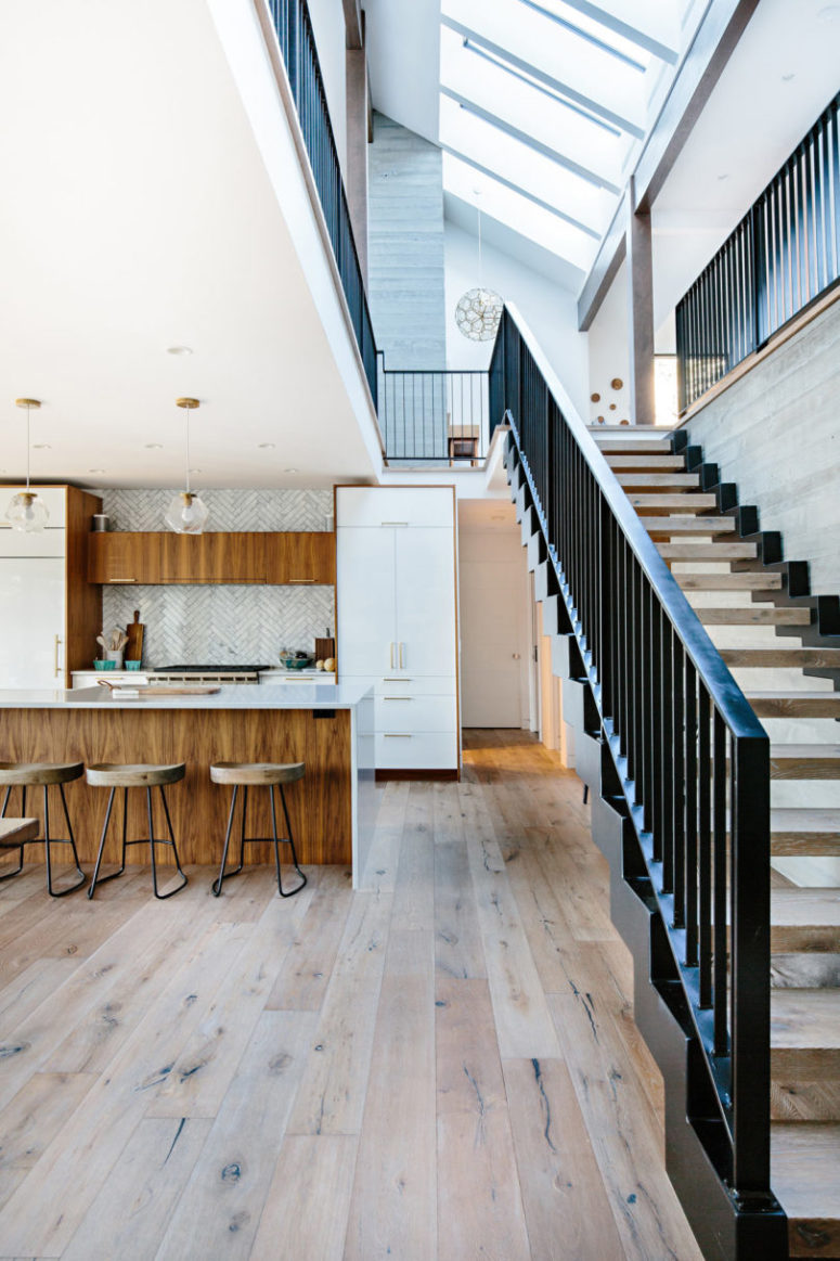 The kitchen is done with chevron clad backsplashes, there's enough wood and white cabinets