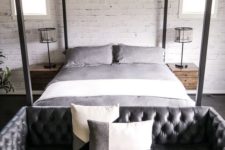 10 an industrial bedroom with a black leather tufted sofa at the foot of the bed that adds style