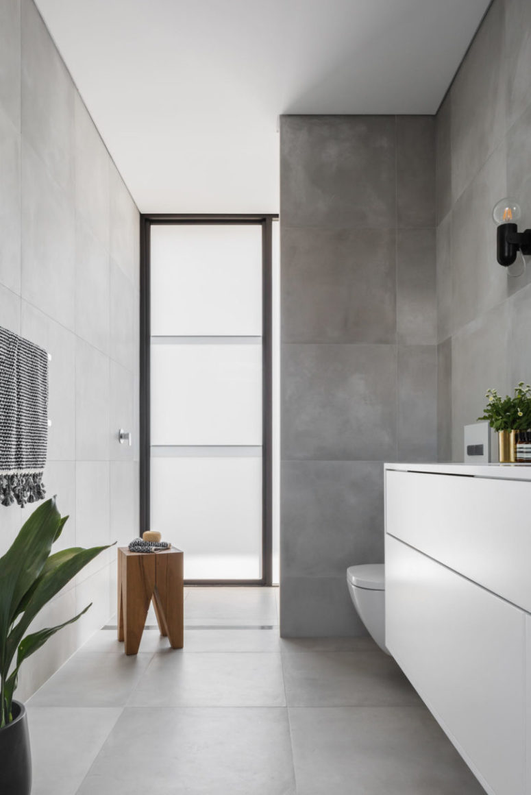 Another bathroom features concrete iles and a frosted glass window