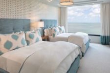 11 a fantastic guest bedroom with two large beds and a gorgeous panoramic sea view