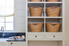 11 a laundry room with an open storage cabinet and a pet bed incorporated into its lower part