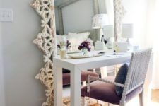 20 a chic vanity space with an oversized mirror and a purple velvet chair with curved legs